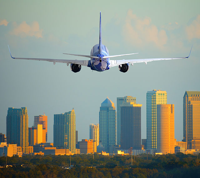 plane landing at Tampa International Airport. Downtown buildings in background